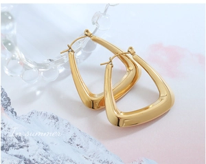 Macro shot of polished gold-plated U-shaped earrings with a chunky geometric design