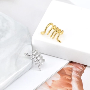 Macro detail of multilayer snake-shaped earrings with realistic scale texture