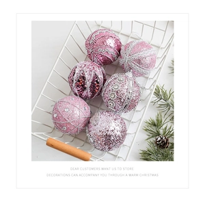 Pink Christmas ornaments set with glitter and sequins in a white wire basket decoration