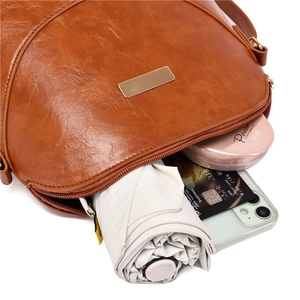 Internal view of the brown leather tote bag showing umbrella, phone, and card storage