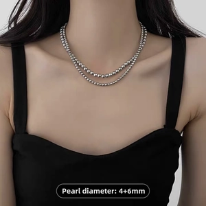 Detail view of double-layered grey pearl necklace with 4mm and 6mm beads on model