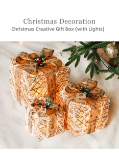Detail of lit Christmas gift boxes with plaid ribbons and warm LED lights on plush rug