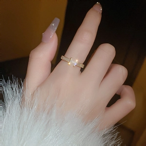 Detail of gold-plated open ring featuring crisscross structure and fine zircon inlay