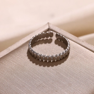 Detailed close-up of a silver stainless steel open ring with vertical oval grain texture