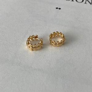 Vue détaillée des boucles d'oreilles feuilles de laurier dorées aux textures creuses