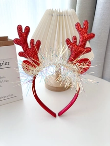 Detailed view of red sequined reindeer antlers headband with festive tinsel and soft ears