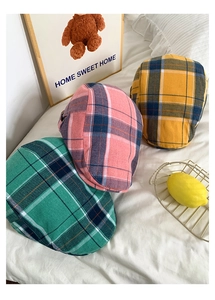 Texture détaillée des casquettes plates à carreaux en tissu rose, vert et jaune