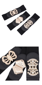 Close-up of three black elastic belts with gold butterfly and rhinestone buckle details
