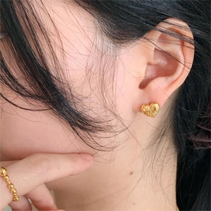 Elegant gold heart bow stud earrings in 925 silver worn for a minimalist Korean style