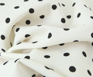 Detailed close-up showing soft white chiffon fabric with classic black polka dot pattern