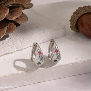 Detail of U-shape silver hoop earrings with star patterns and colorful zircon stones