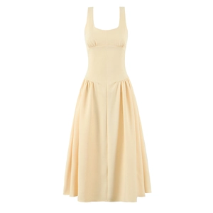 Détail d'une robe évasée beige sans manches avec taille cintrée et ourlet plissé élégant