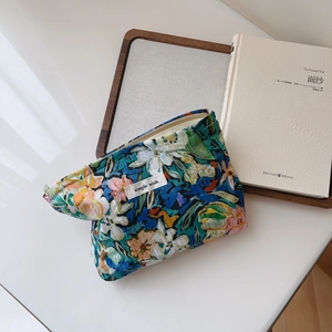 Floral print cotton makeup bag with metal zipper and Simple Wish woven label on desk