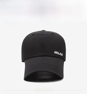 Detailed close-up of white NALAS embroidery on a premium black cotton baseball cap
