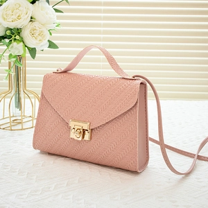 Pink textured crossbody handbag with golden metal lock and shoulder strap in soft light
