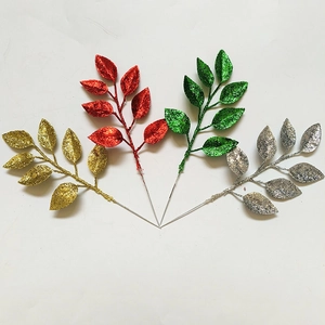 Close-up of glittery artificial Christmas leaf branches in gold, red, green, and silver