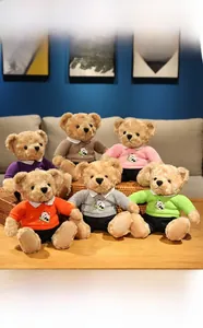Collection of plush teddy bears in colorful panda hoodies displayed on a wooden table