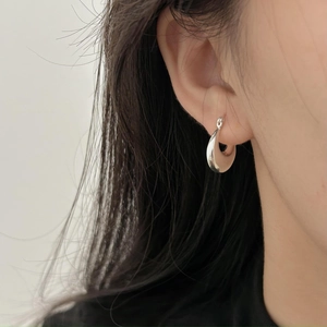 Minimalist 925 sterling silver U-shaped hoop earrings on model with sleek drop design