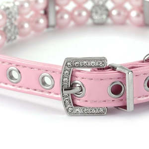Detail of pink faux leather pet collar with triple-row pearls and rhinestone buckle