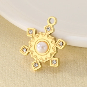 Detail of golden snowflake pendant with central pearl and sparkling rhinestones
