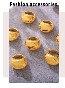 Flat lay of six irregular polished 18K gold-plated stainless steel rings on gray fabric
