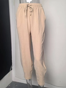 Gros plan du pantalon décontracté beige avec tissu texturé et taille élastique à cordon