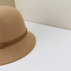 Detail of camel wool felt hat showing the brown leather strap and fine stitching