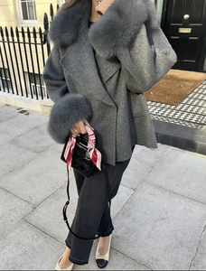 Détail d'un manteau en laine grise avec garniture en fourrure au col et poignets