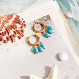 Detail of 18k gold stainless steel hoop earrings featuring three turquoise-colored beads