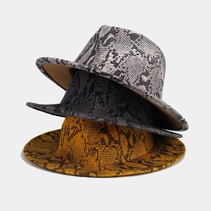 Detailed texture of snakeskin print wool fedora hats in black, grey, and ginger yellow