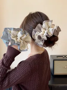 Detail of houndstooth and lace scrunchies on model in a cozy home setting