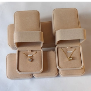 Detail view of premium beige velvet necklace boxes with elegant golden pendants inside