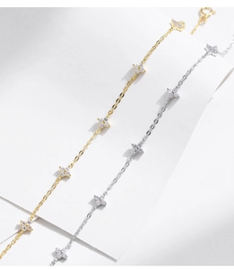 Detailed view of silver and gold clover bracelets with sparkling cubic zirconia stones