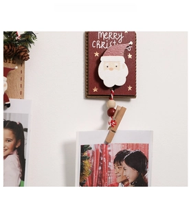 Détail d'un pince à photos Père Noël en bois avec texte Merry Christmas et ficelle rouge