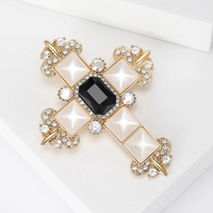 Macro shot of a baroque cross brooch with large black stone and crystals on a white stand