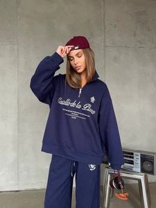 Detail of navy blue half-zip sweatshirt set with high-waisted wide-leg sweatpants in retro style