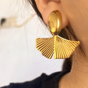 Chic golden ginkgo leaf stud earrings with fan-shaped metallic texture on model