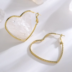 Textured gold heart earrings for women displayed on a clean white surface