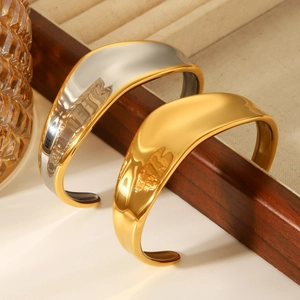 Detailed view of wide 18K gold plated and bicolor stainless steel open cuff bracelets
