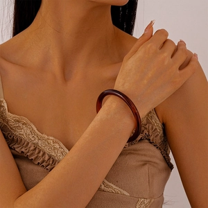 Detail of amber acrylic resin bangle worn on wrist with elegant minimalist design