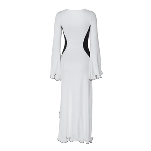 Détail de la robe maxi blanche à manches longues avec empiècement noir et ourlet volanté