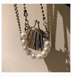 Detail der silbernen Mini-Tasche in Muschelform mit großem Perlengriff und Metallkette