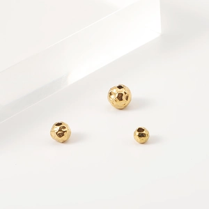Macro detail of golden hammered stainless steel beads for DIY jewelry making and crafting