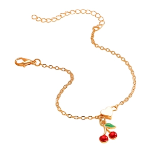 Dettaglio del bracciale dorato con ciondolo a ciliegia e cuore con estensione