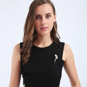 Silver leaf brooch with inlaid zircons worn on a black dress against a white background