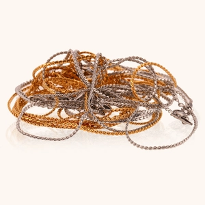 Detail of assorted gold and silver stainless steel chain necklaces in various weaves