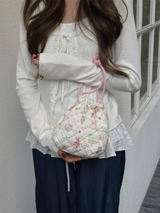 Detail of quilted drawstring bag with cute pink bear, strawberry and bow patterns