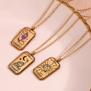 Macro shot of three 18K gold plated tarot card pendants showing Lovers, Strength and World