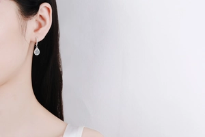 Close-up of elegant S925 sterling silver teardrop earrings with moissanite on model