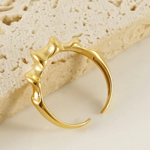Detail of 18K gold-plated irregular wave ring on a minimalist stone display stand